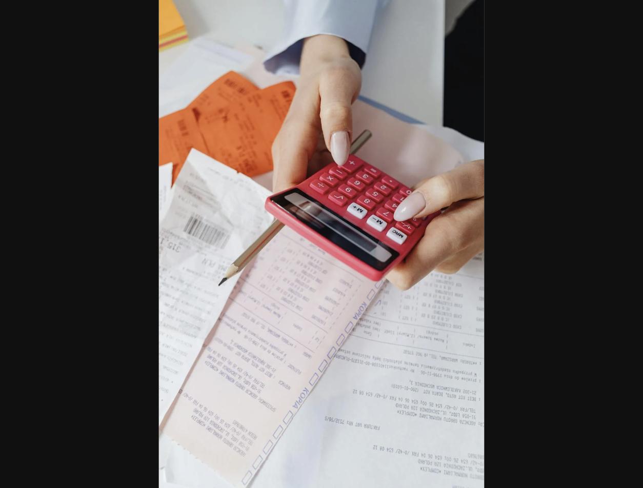 Person reviewing documents with calculator for affordable NAATI translation cost comparison