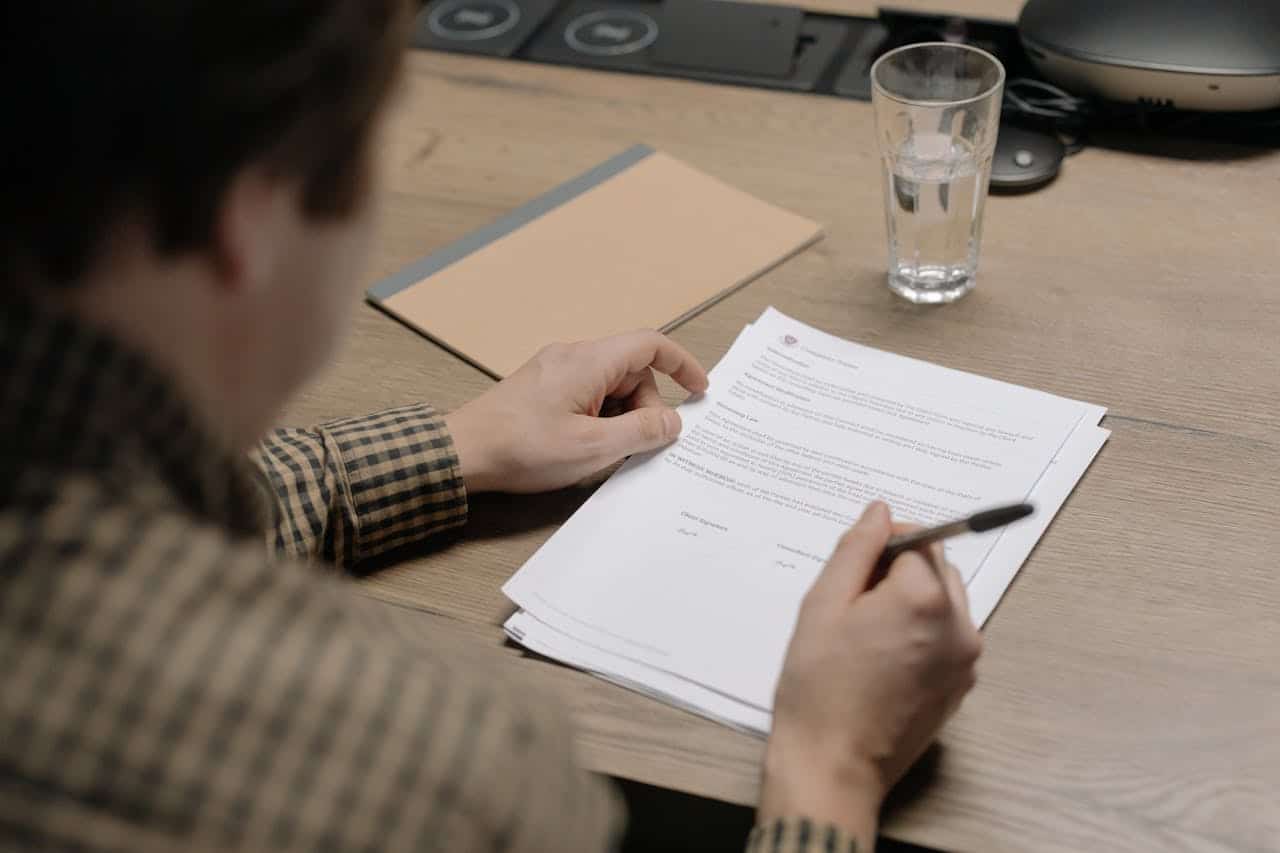 Man signing contract representing hidden costs of overseas translation services for Australian visas