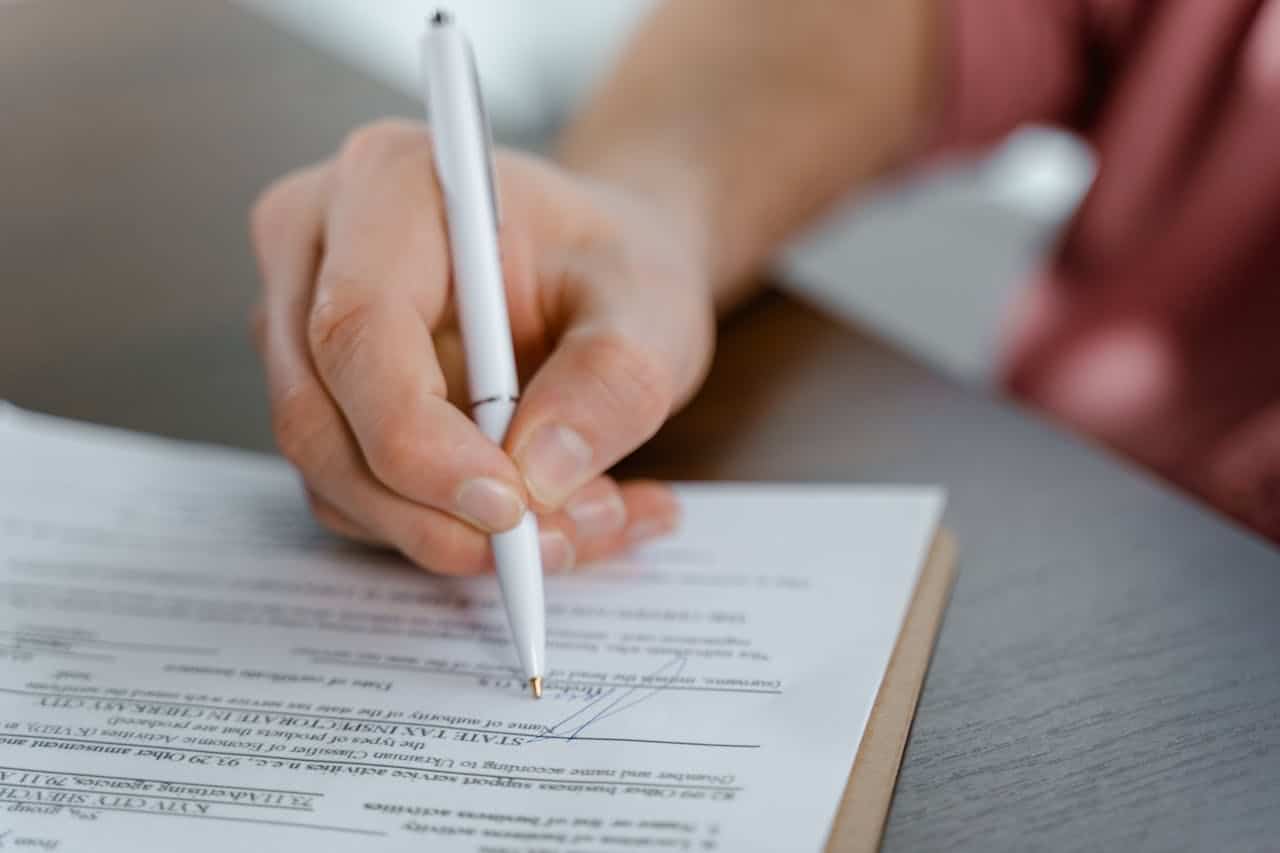 Person signing official NAATI certified translation document in Australia